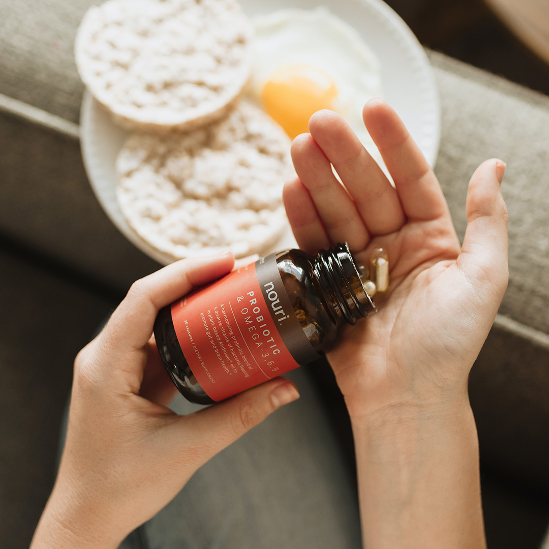 a woman pouring supplements into her hand