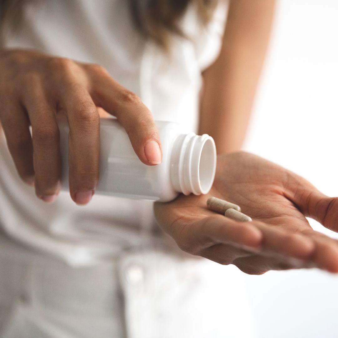 Person dispensing supplements from bottle