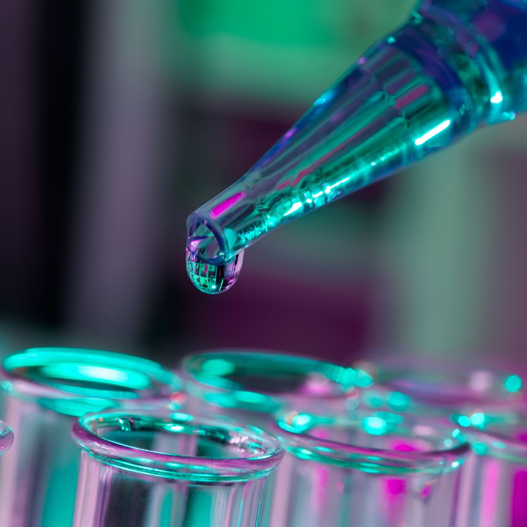 Person piping a substance into test tubes.