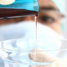 chemist combining substance into a glass jar